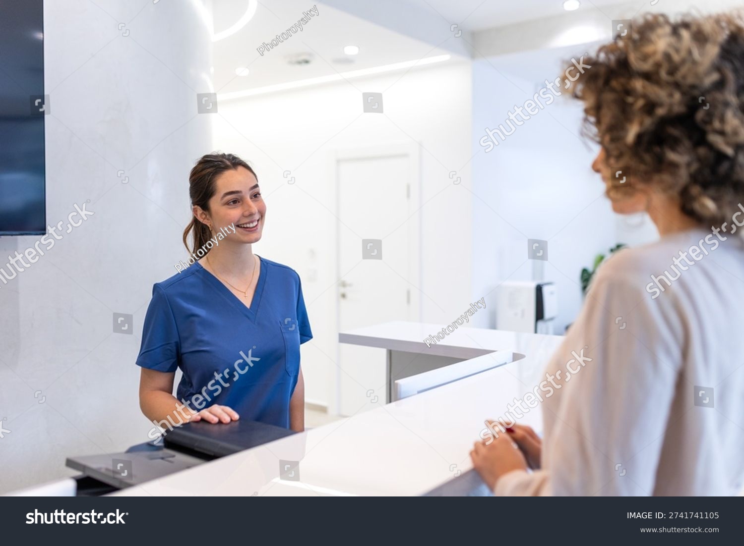 Front desk staff checking in a patient